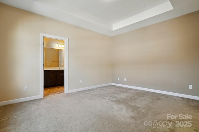 11209 Lazio Ln Unit 1, Charlotte, NC 28277 - unfurnished bedroom with light carpet, a tray ceiling, baseboards, and ensuite bath