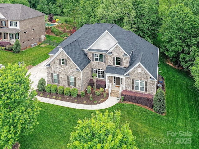 129 Overlook Ridge Ln, Davidson, NC 28036 - craftsman-style house featuring stone siding, a front yard, and a shingled roof