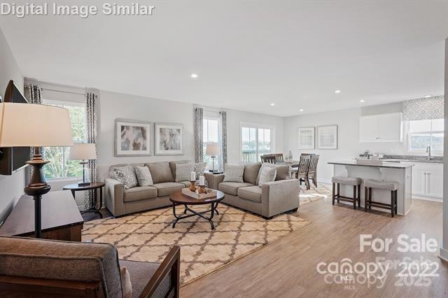 living room with plenty of natural light, light wood-style floors, and recessed lighting