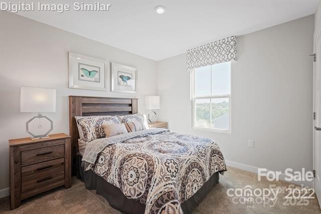 carpeted bedroom featuring baseboards