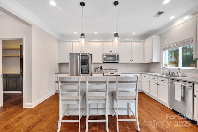 1225 Madison Green Dr, Fort Mill, SC 29715 - kitchen with appliances with stainless steel finishes, white cabinetry, recessed lighting, a center island, and decorative light fixtures