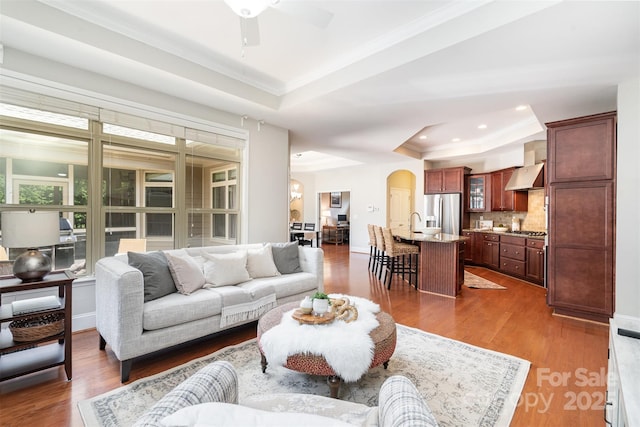5214 Polo Gate Blvd, Charlotte, NC 28216 - living area with a raised ceiling, arched walkways, ornamental molding, baseboards, and dark wood-style flooring