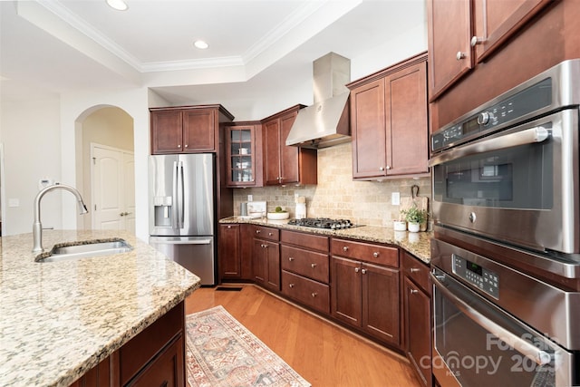 5214 Polo Gate Blvd, Charlotte, NC 28216 - kitchen with appliances with stainless steel finishes, a sink, wall chimney exhaust hood, light wood-type flooring, and arched walkways