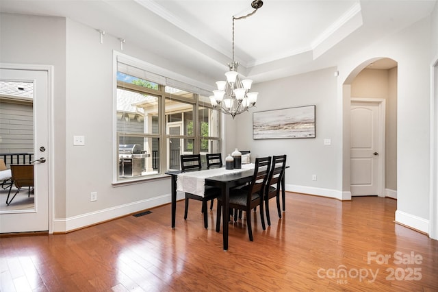 5214 Polo Gate Blvd, Charlotte, NC 28216 - dining space with wood finished floors, arched walkways, a chandelier, a tray ceiling, and baseboards