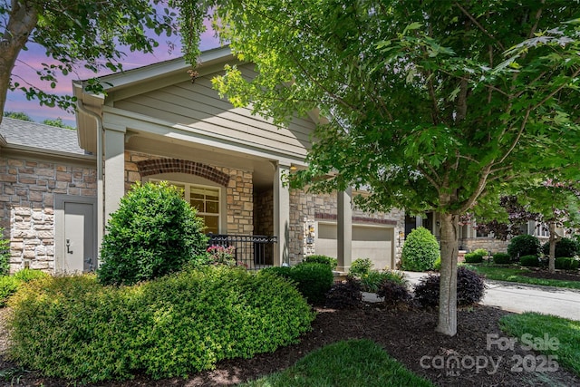 5214 Polo Gate Blvd, Charlotte, NC 28216 - view of front facade featuring stone siding, a garage, covered porch, and driveway