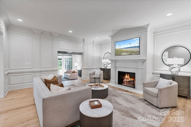 4920 Parview Dr S, Charlotte, NC 28226 - living room with a fireplace with flush hearth, crown molding, light wood-type flooring, a decorative wall, and recessed lighting
