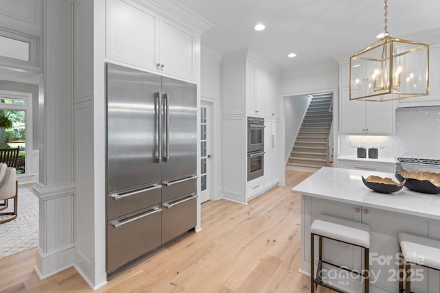 4920 Parview Dr S, Charlotte, NC 28226 - kitchen featuring stainless steel appliances, white cabinetry, a chandelier, light wood finished floors, and recessed lighting