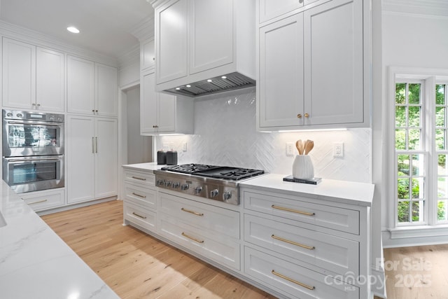 4920 Parview Dr S, Charlotte, NC 28226 - kitchen featuring stainless steel appliances, decorative backsplash, white cabinetry, light wood-type flooring, and crown molding
