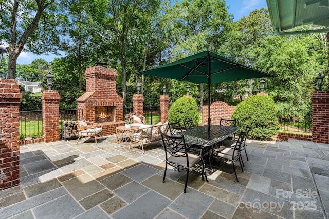 4920 Parview Dr S, Charlotte, NC 28226 - view of patio / terrace with an outdoor brick fireplace, view of scattered trees, and outdoor dining area