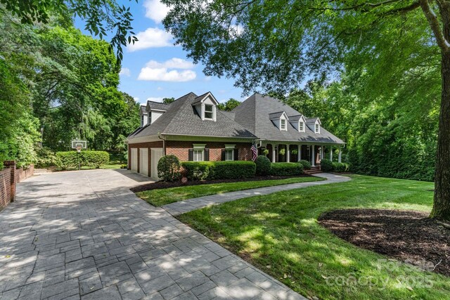 4920 Parview Dr S, Charlotte, NC 28226 - cape cod home with an attached garage, brick siding, a front yard, driveway, and a shingled roof