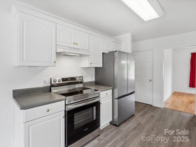 1028 Swaying Oats Dr, York, SC 29745 - kitchen featuring appliances with stainless steel finishes, under cabinet range hood, light wood-style floors, white cabinetry, and dark countertops