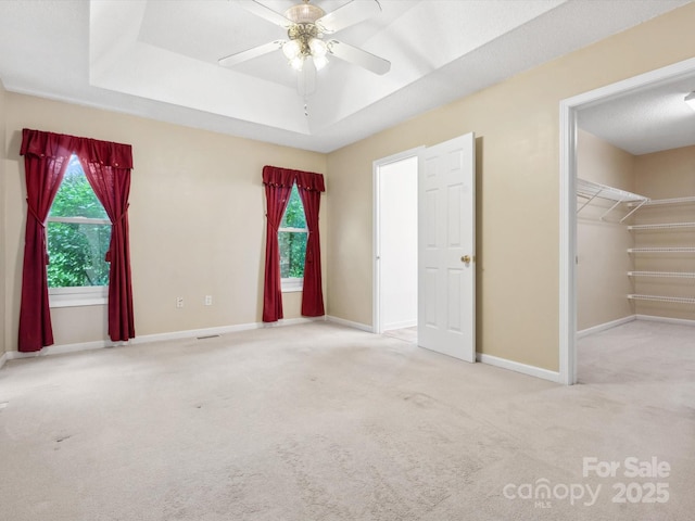 1028 Swaying Oats Dr, York, SC 29745 - unfurnished bedroom with carpet floors, a tray ceiling, baseboards, a walk in closet, and a ceiling fan