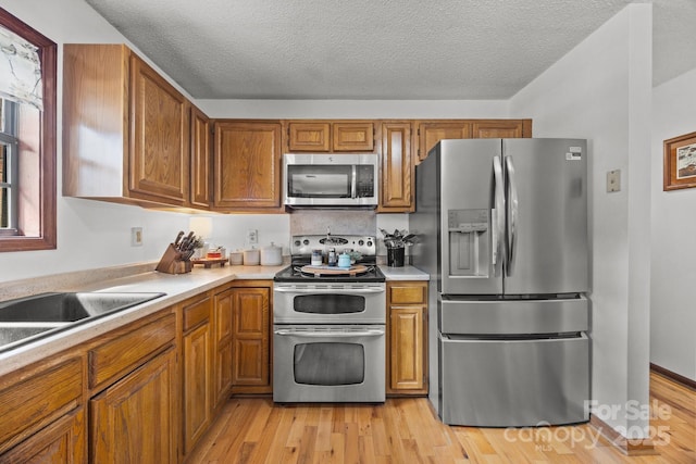 425 Troutman Rd, Rockwell, NC 28138 - kitchen with appliances with stainless steel finishes, light countertops, brown cabinetry, and a textured ceiling