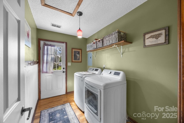 425 Troutman Rd, Rockwell, NC 28138 - clothes washing area featuring washer and clothes dryer, light wood-type flooring, and a textured ceiling