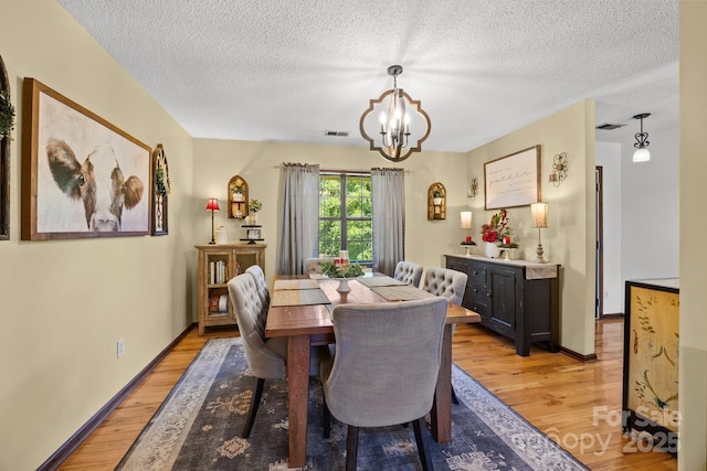 425 Troutman Rd, Rockwell, NC 28138 - dining space with light wood-style flooring, a chandelier, a textured ceiling, and baseboards