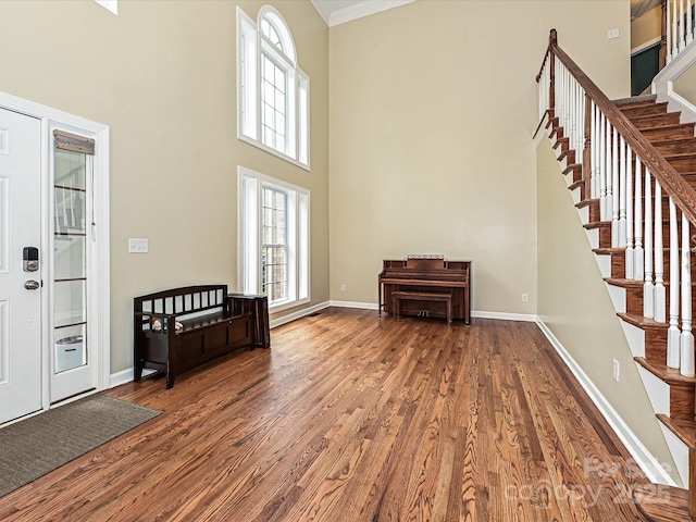 410 Deer Brush Ln, Waxhaw, NC 28173 - foyer entrance featuring wood finished floors, a towering ceiling, healthy amount of natural light, stairway, and ornamental molding