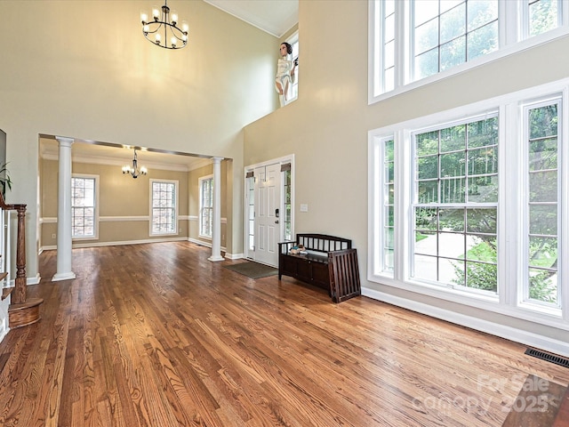 410 Deer Brush Ln, Waxhaw, NC 28173 - entryway with a chandelier, decorative columns, a high ceiling, crown molding, and wood finished floors