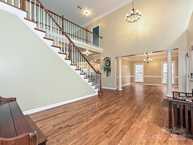 410 Deer Brush Ln, Waxhaw, NC 28173 - foyer with a chandelier, decorative columns, crown molding, wood finished floors, and a towering ceiling
