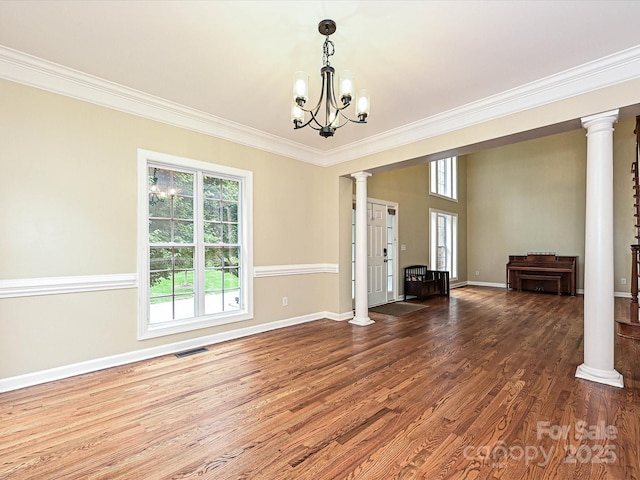 410 Deer Brush Ln, Waxhaw, NC 28173 - unfurnished living room featuring healthy amount of natural light, a chandelier, ornamental molding, wood finished floors, and baseboards