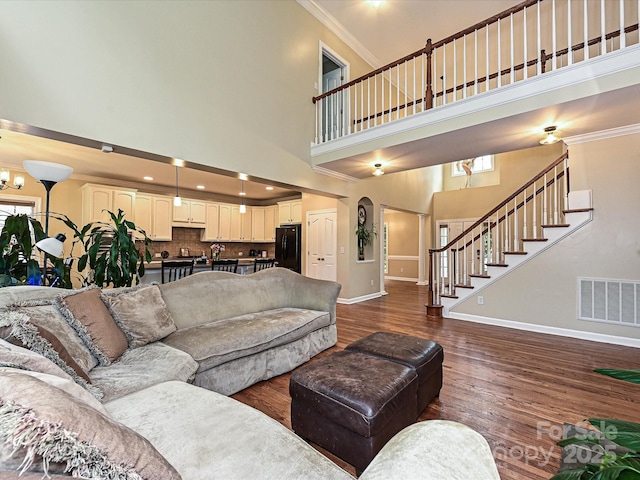 410 Deer Brush Ln, Waxhaw, NC 28173 - living room featuring baseboards, a high ceiling, dark wood finished floors, ornamental molding, and stairs