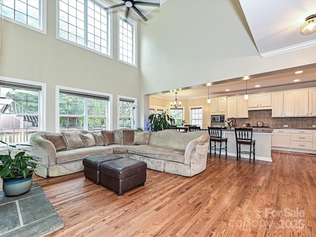 410 Deer Brush Ln, Waxhaw, NC 28173 - living area with a chandelier, a high ceiling, light wood-style flooring, ornamental molding, and recessed lighting