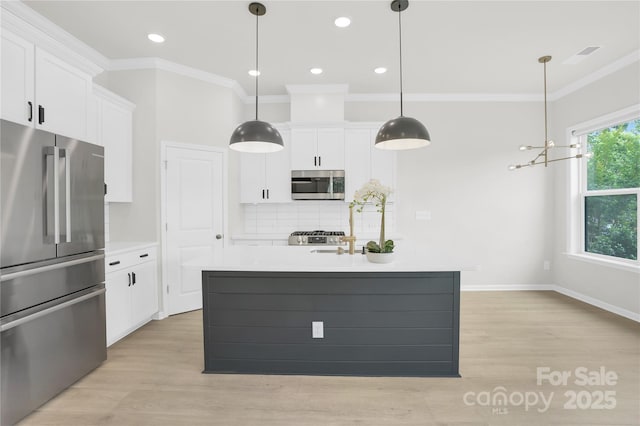 5946 Ardrey Kell Rd, Charlotte, NC 28277 - kitchen featuring appliances with stainless steel finishes, ornamental molding, white cabinetry, light wood-style floors, and light countertops