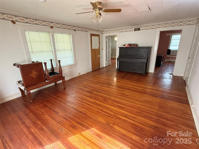 spare room with hardwood / wood-style floors, a ceiling fan, ornamental molding, and baseboards