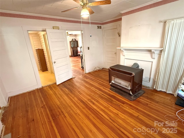 living room with ornamental molding, a ceiling fan, and light wood-style flooring