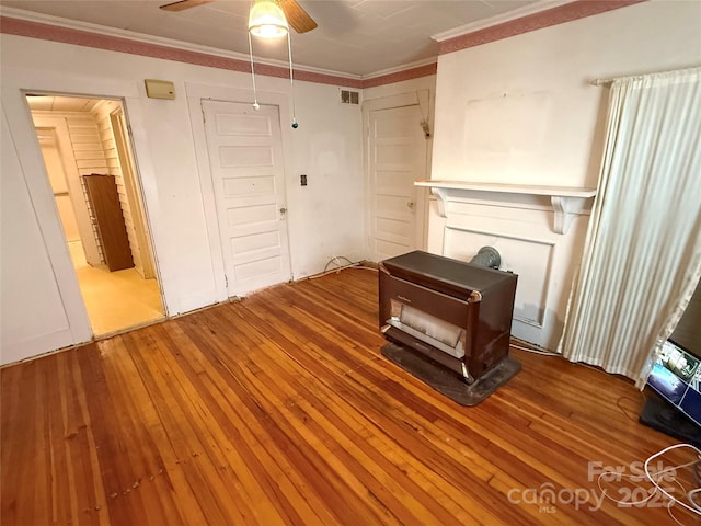 living room featuring wood-type flooring, a ceiling fan, and ornamental molding