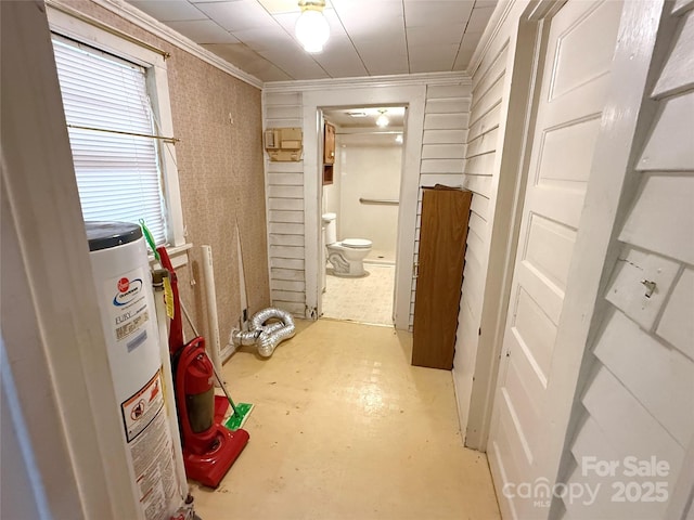 hallway with water heater, ornamental molding, and concrete floors