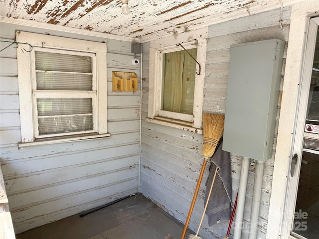 empty room with concrete flooring and wooden walls
