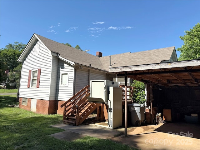 view of front of property with a front lawn, a chimney, and roof with shingles