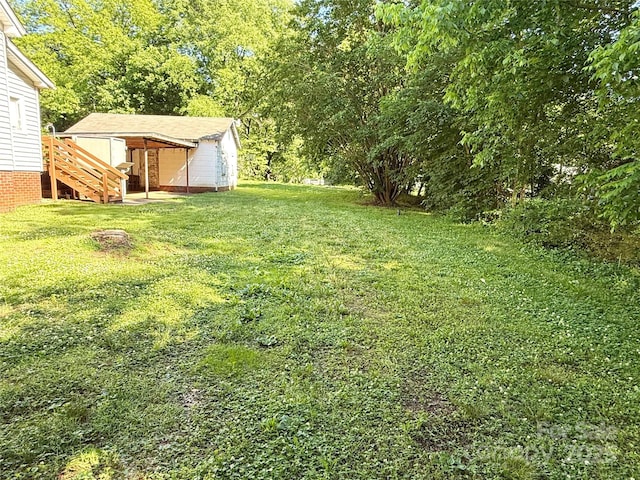 view of green lawn featuring an outdoor structure