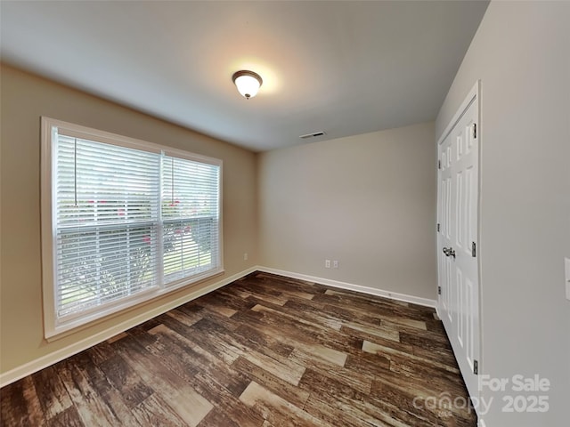 unfurnished bedroom with dark wood-type flooring, baseboards, and a closet