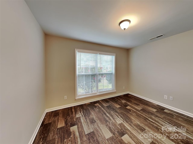 empty room featuring dark wood finished floors and baseboards