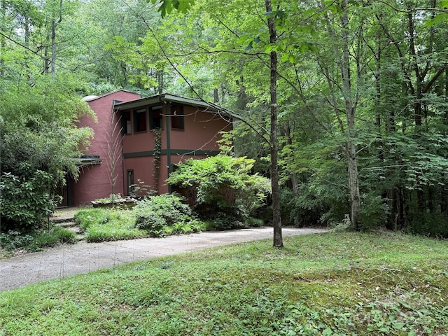 view of home's exterior with a forest view and stucco siding
