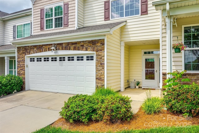 809 River Park Rd, Belmont, NC 28012 - view of exterior entry featuring an attached garage, stone siding, driveway, and a shingled roof