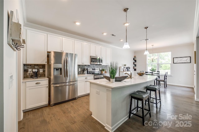 809 River Park Rd, Belmont, NC 28012 - kitchen with stainless steel appliances, dark wood-style floors, decorative backsplash, a breakfast bar area, and ornamental molding