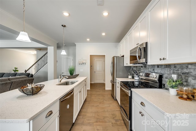 809 River Park Rd, Belmont, NC 28012 - kitchen with appliances with stainless steel finishes, a sink, ornamental molding, white cabinets, and light wood-style floors