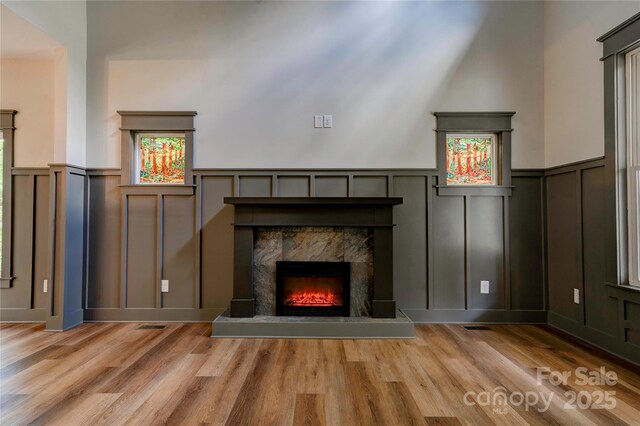 600 S Cline Ave, Newton, NC 28658 - unfurnished living room featuring a decorative wall, wood finished floors, a premium fireplace, and wainscoting
