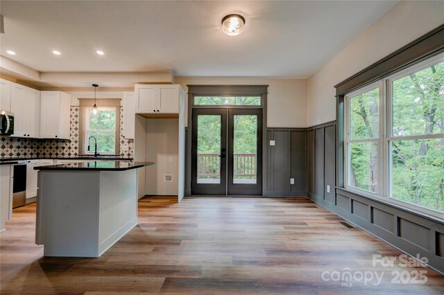 600 S Cline Ave, Newton, NC 28658 - kitchen with stainless steel electric range, white cabinets, dark countertops, plenty of natural light, and a decorative wall