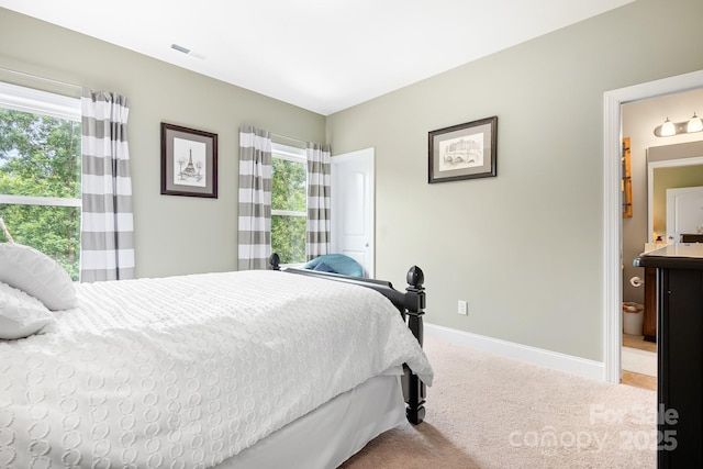 10911 Skymont Dr, Huntersville, NC 28078 - carpeted bedroom featuring multiple windows, baseboards, and connected bathroom