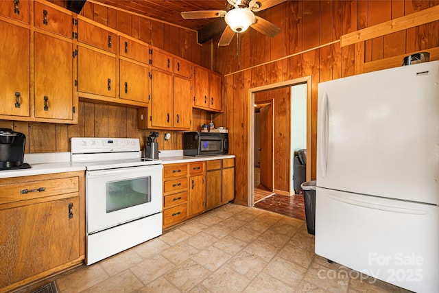 61 Magnolia Dr, Canton, NC 28716 - kitchen featuring white appliances, light countertops, wood walls, a ceiling fan, and brown cabinets