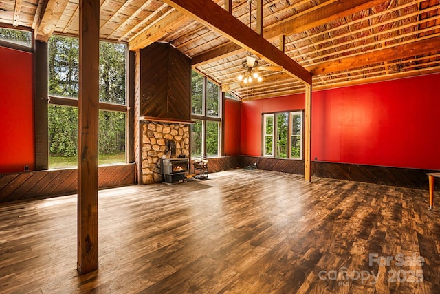 61 Magnolia Dr, Canton, NC 28716 - unfurnished living room with wood-type flooring, a wood stove, lofted ceiling, wooden walls, and a chandelier