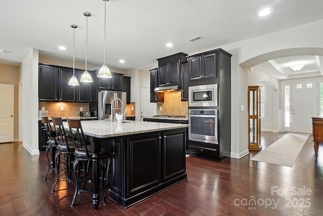 161 Leaning Tower Dr, Mooresville, NC 28117 - kitchen with appliances with stainless steel finishes, arched walkways, dark cabinetry, recessed lighting, and dark wood-style floors
