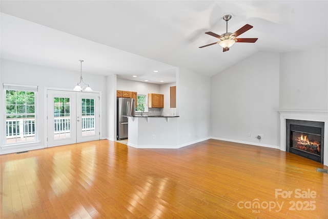 unfurnished living room with ceiling fan, light wood-style floors, a glass covered fireplace, plenty of natural light, and recessed lighting