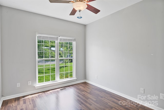 unfurnished room featuring healthy amount of natural light, baseboards, and wood finished floors