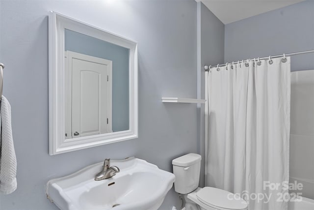 bathroom featuring a sink, toilet, and shower / bathtub combination with curtain