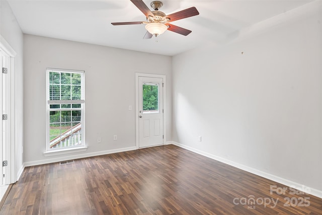 empty room with healthy amount of natural light, wood finished floors, baseboards, and a ceiling fan