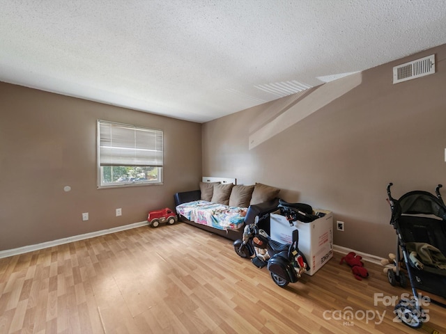 7977 Shady Oak Trl, Charlotte, NC 28210 - unfurnished bedroom featuring a textured ceiling, wood finished floors, and baseboards